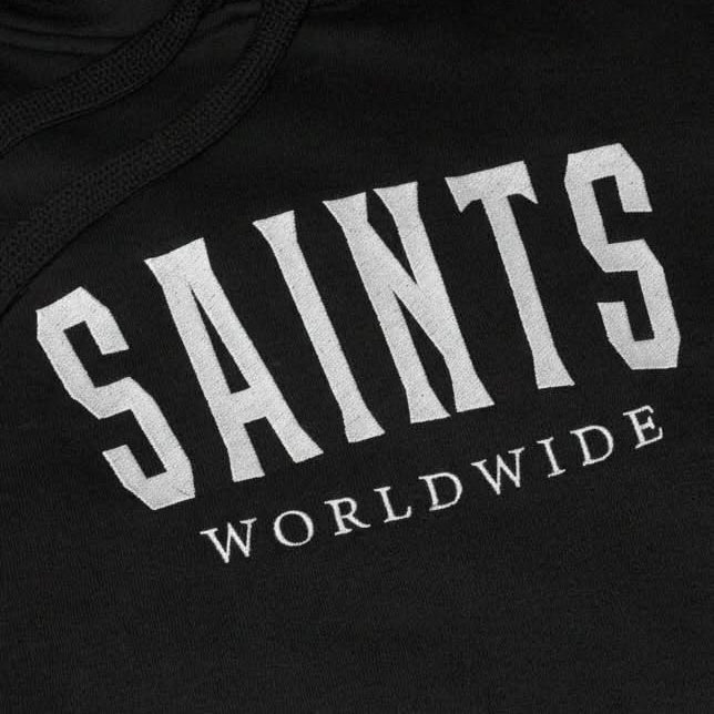 Close-up of Saints Worldwide logo embroidered on front of black Christian hoodie