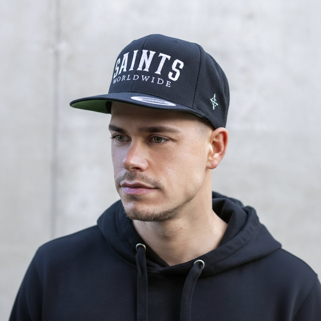 Model wearing SAINTS WORLDWIDE black snapback, front-facing close-up