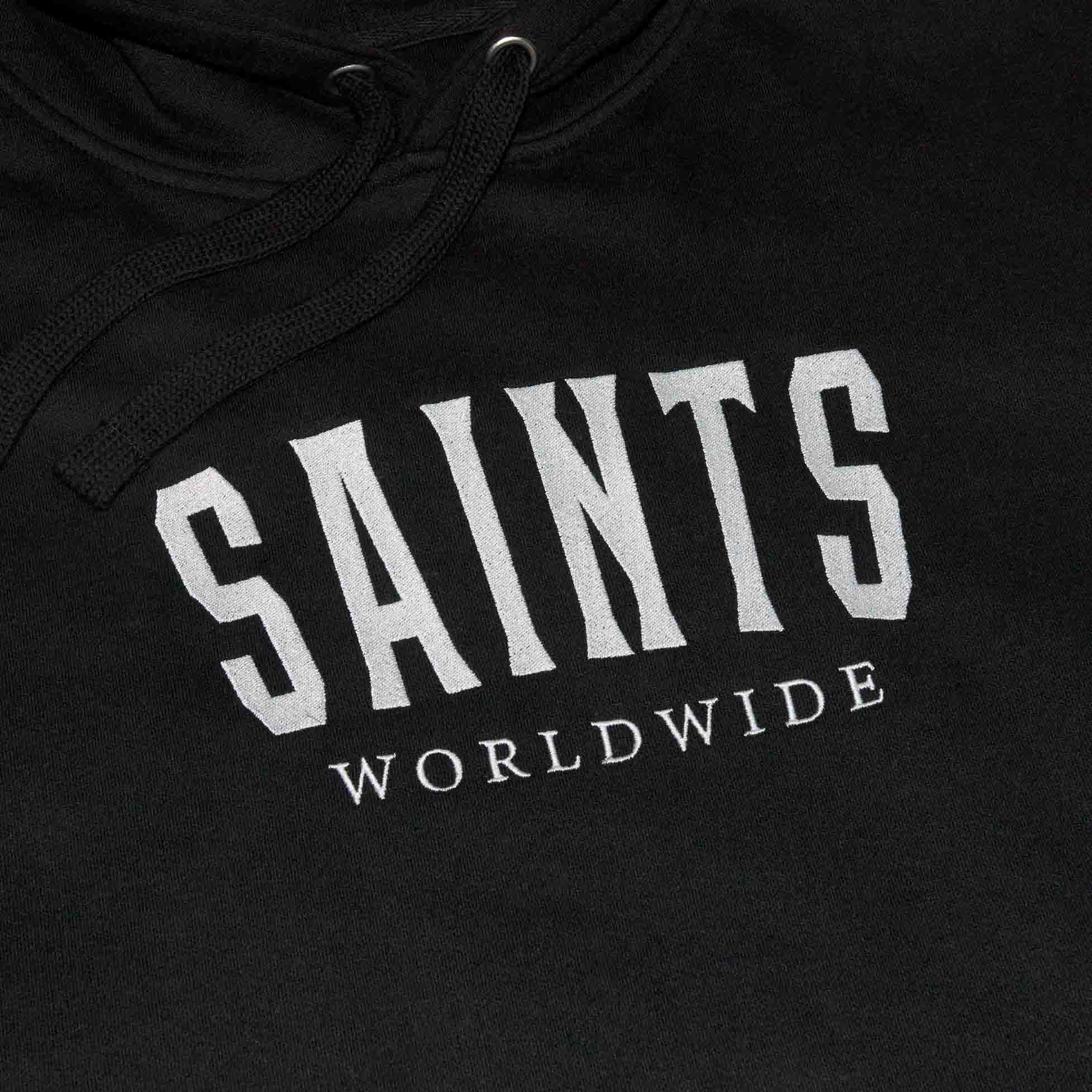 Close-up of the embroidered SAINTS WORLDWIDE chest logo on the black hoodie