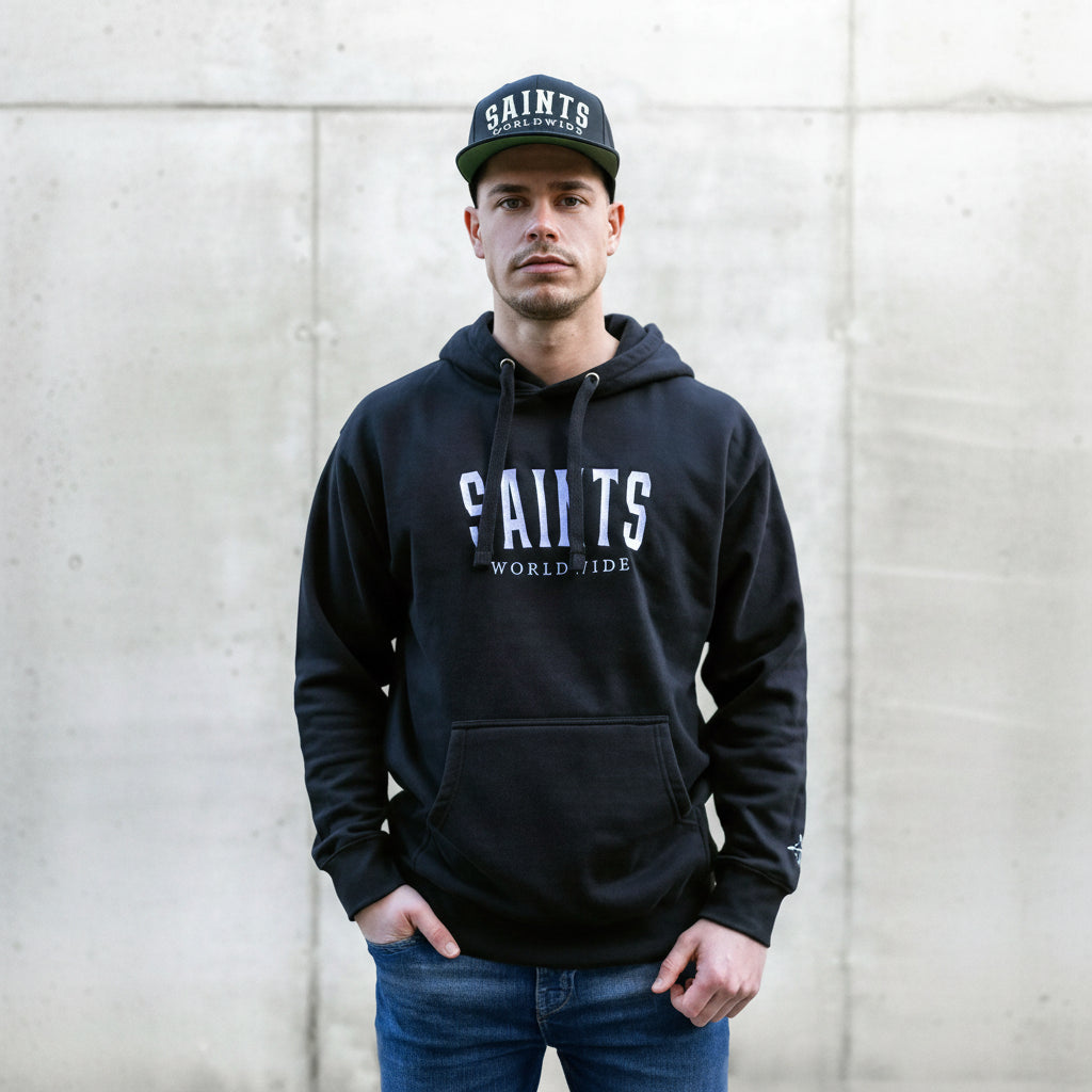 Male model wearing Christian black hoodie with Saints Worldwide logo on front