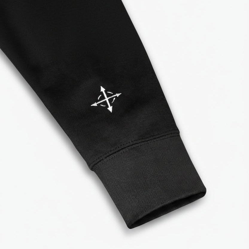 Close-up of compass arrow embroidery on hoodie sleeve – Christian symbolism